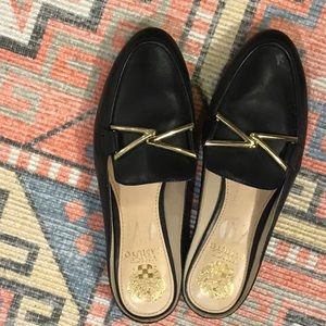Vince Camuto black backless loafers w/ gold colored hardware.
